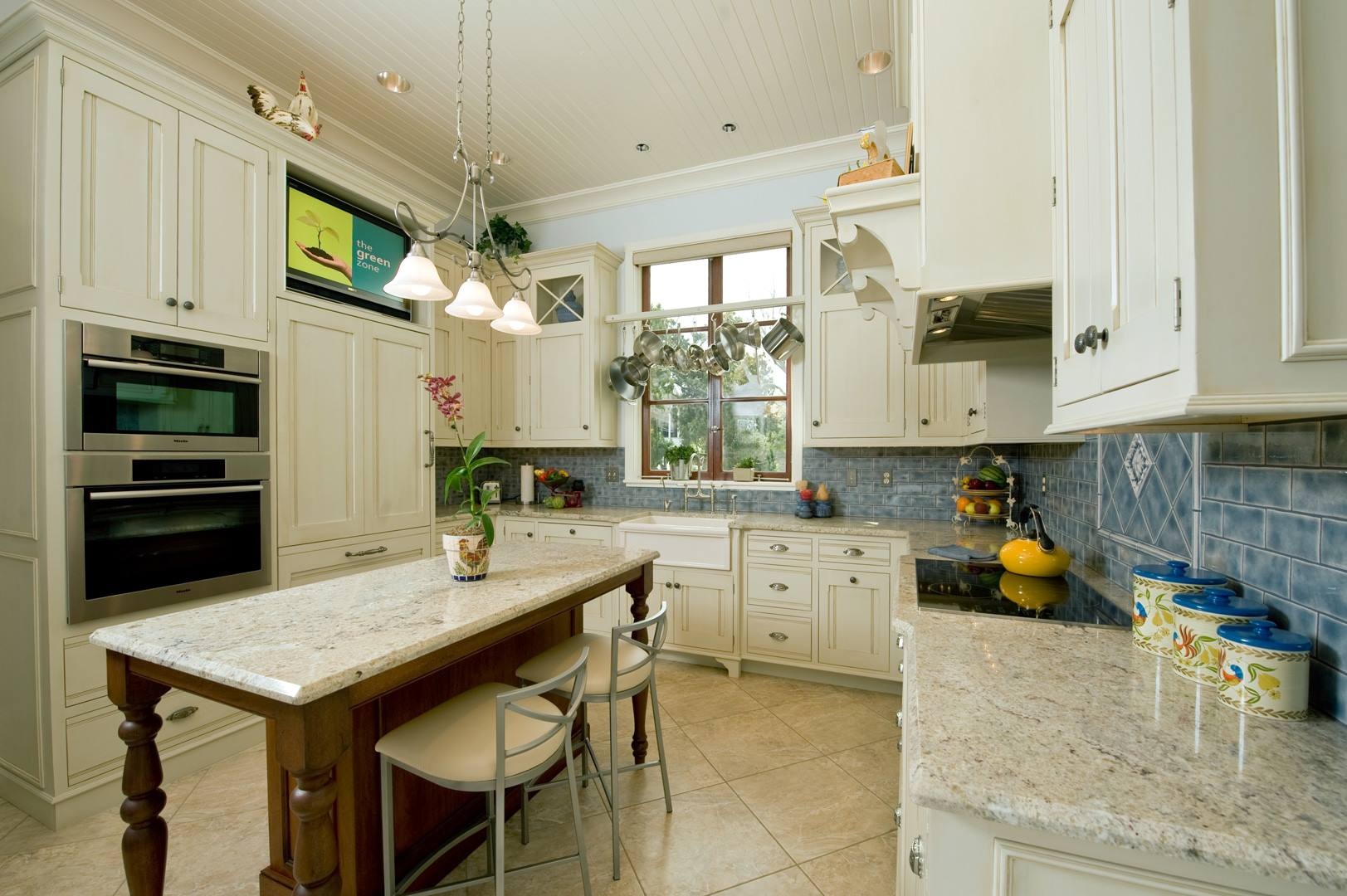 Bright, open-concept kitchen with light wood cabinets and a marble island.